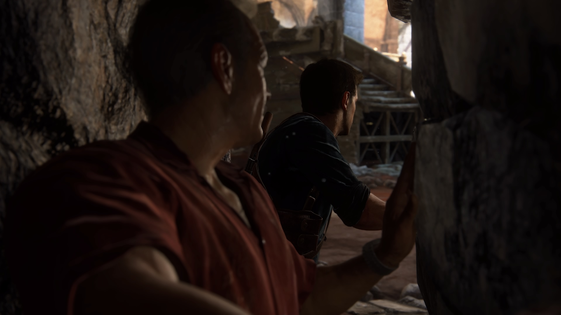 Nathan Drake wedges through the hallway crevice to discover a hidden room